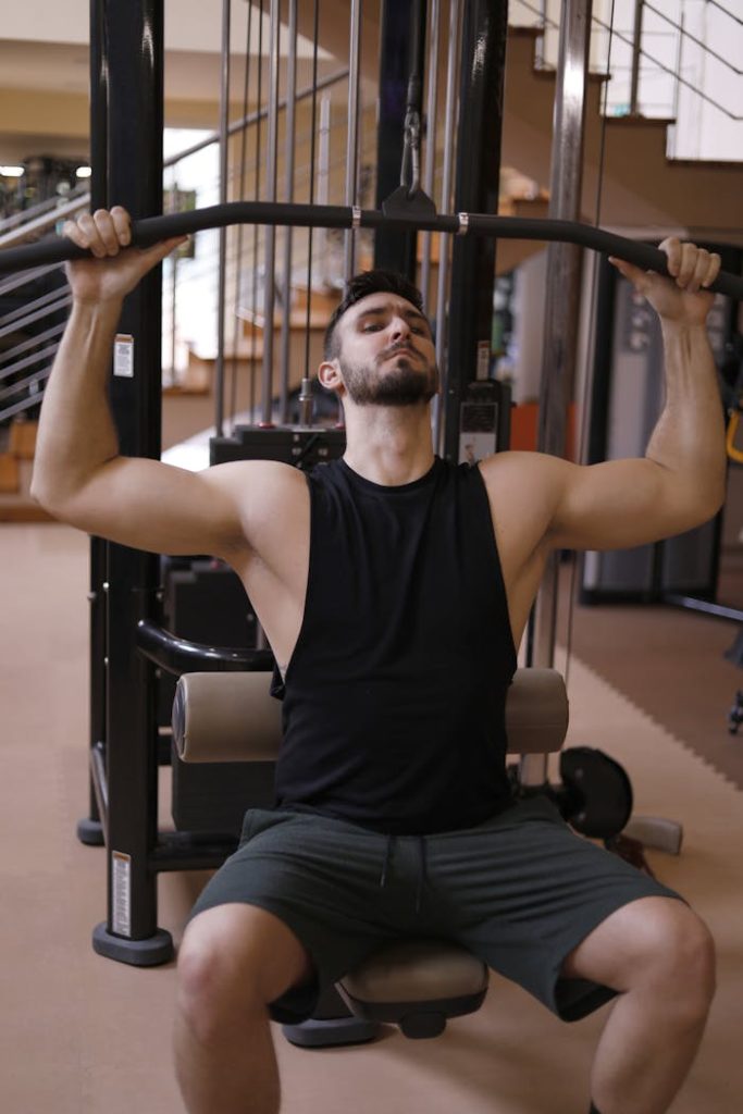 Athletic man working out on weight machine in the gym.